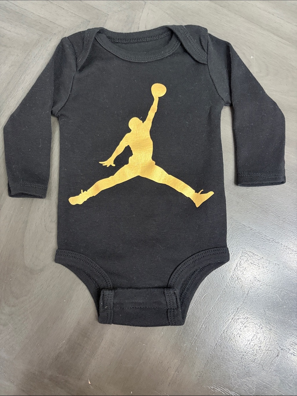 Jordan Black One-Piece Bodysuit with Gold Jumpman Graphic